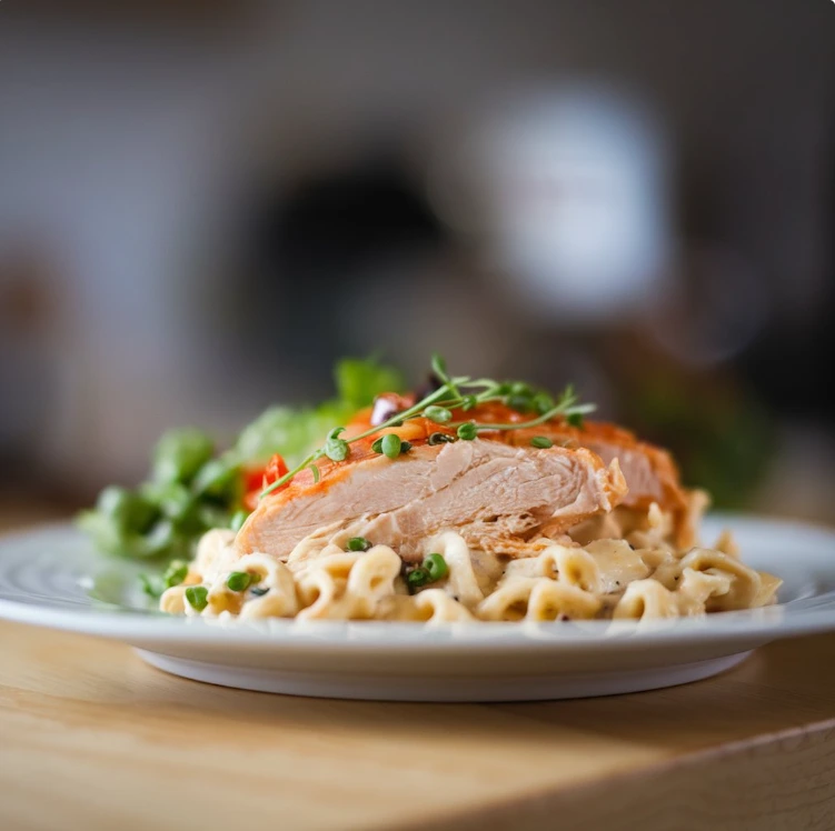 A creamy Chicken Alfredo dish with fettuccine pasta and grilled chicken, garnished with Parmesan cheese and parsley.